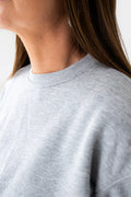 Gray sweatshirt worn by a person with a neutral background